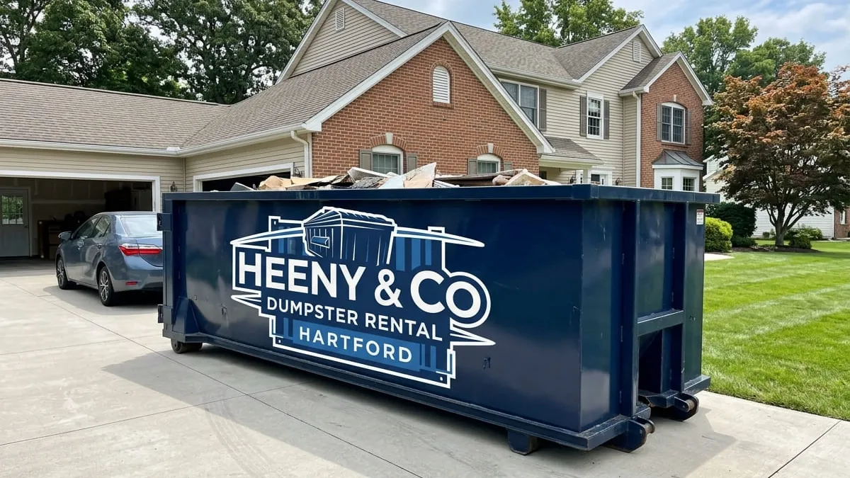Heeny & Co Dumpster Rental crew standing with a roll-off truck and 30 yard dumpster in a Hartford, CT driveway Heeny & Co Dumpster Rental crew standing with a roll-off truck and 30 yard dumpster in a Hartford, CT driveway
